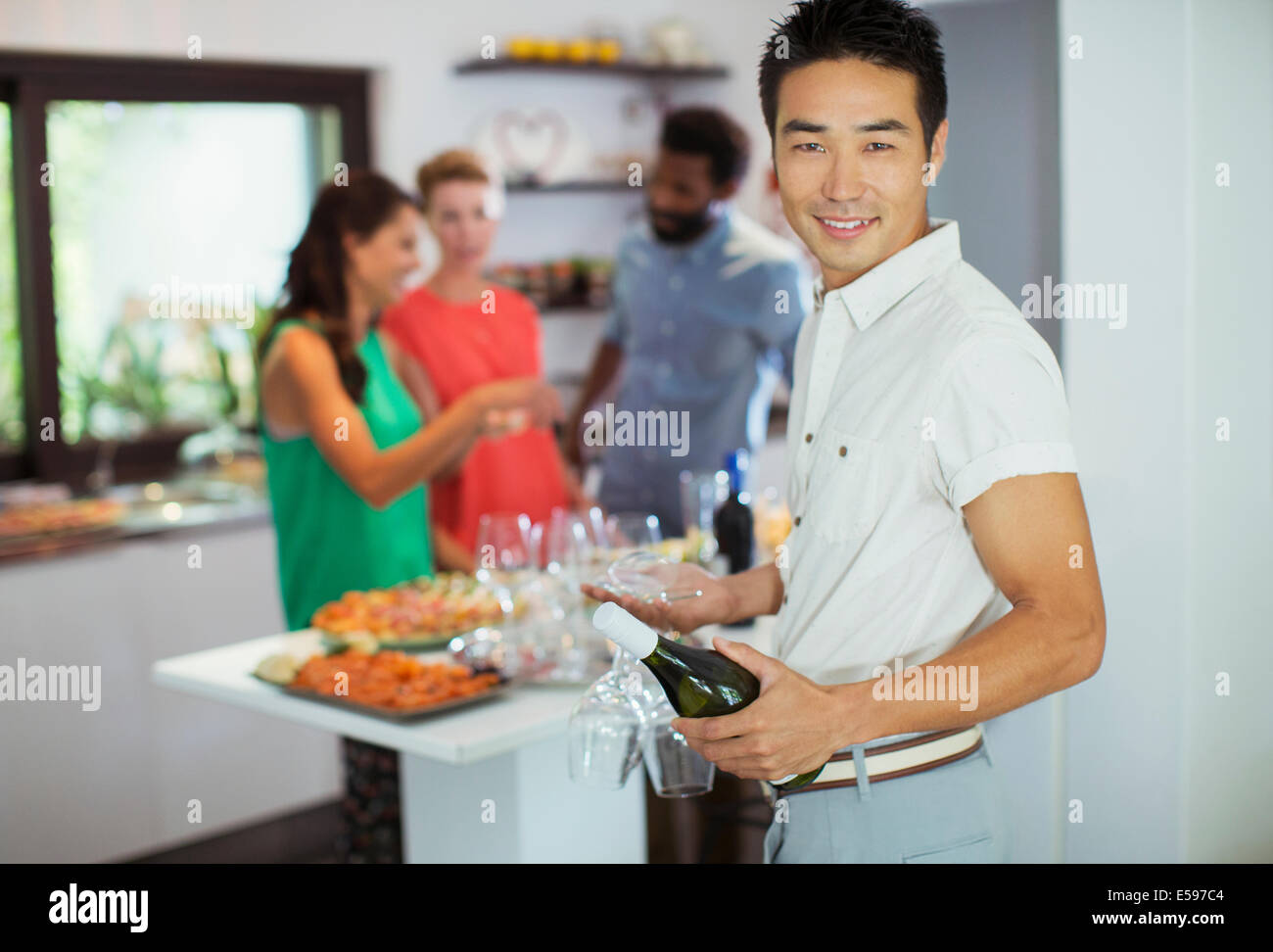 Man carrying bottle of wine at party Stock Photo
