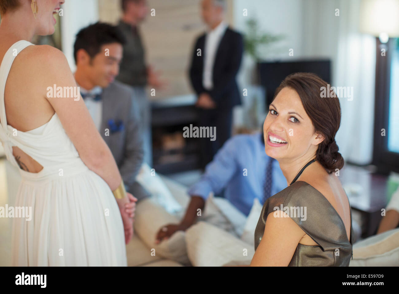 Woman smiling on sofa at party Stock Photo
