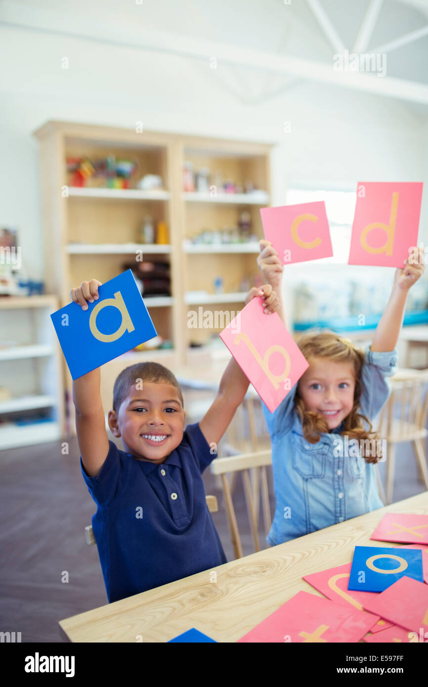 Students holding letters in classroom Stock Photo