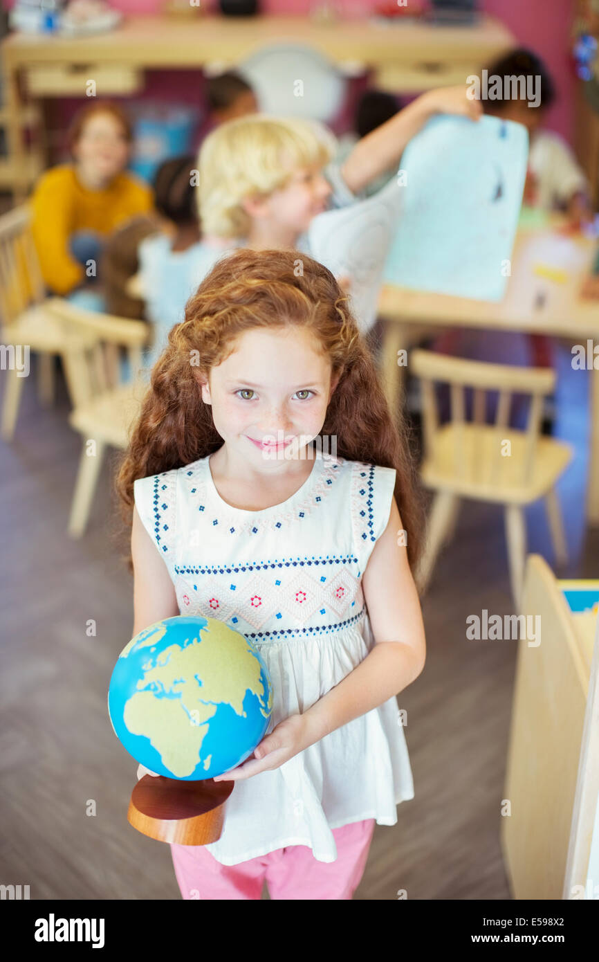 Student holding globe in classroom Stock Photo - Alamy