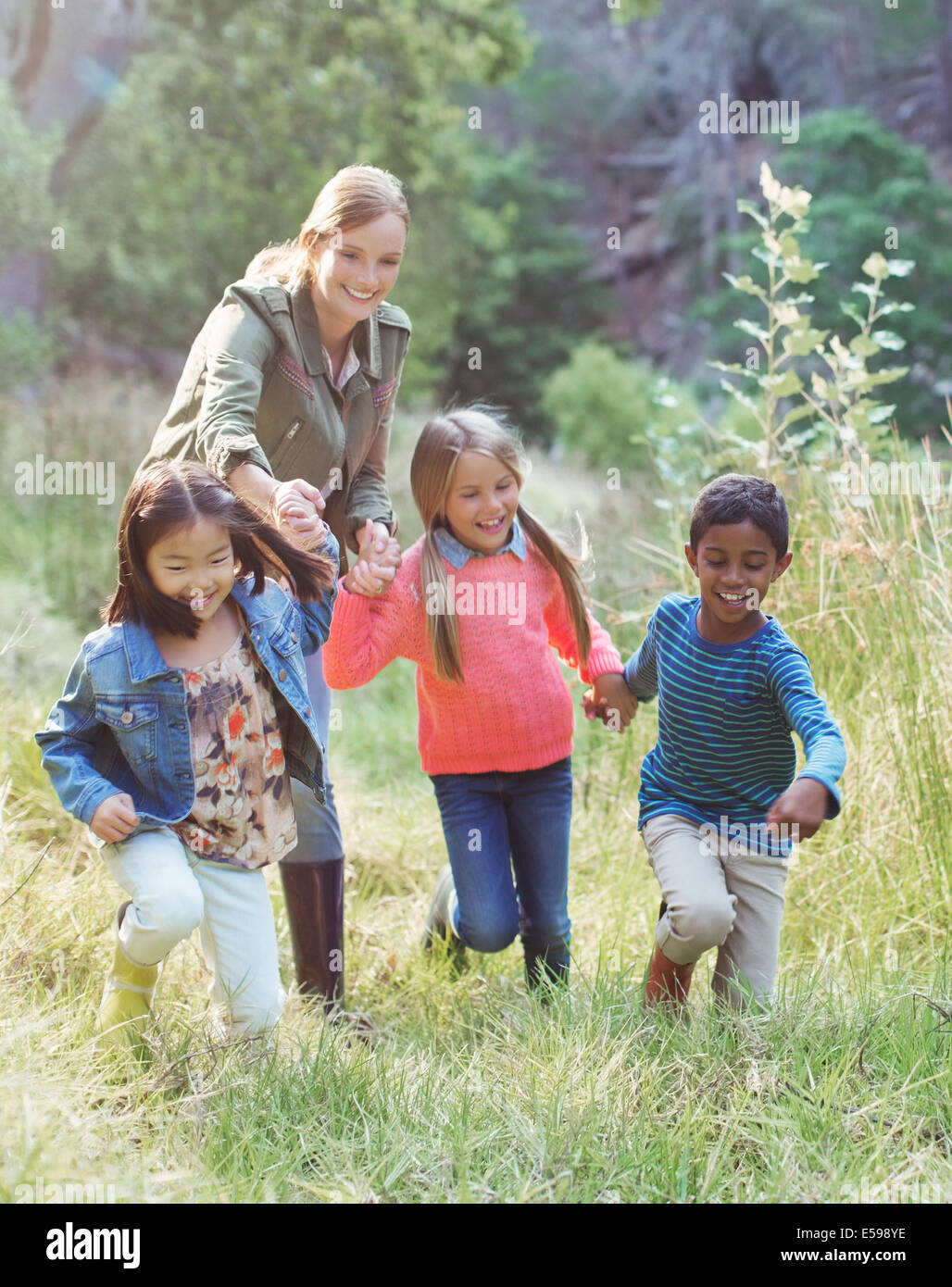 Students and teacher walking in field Stock Photo