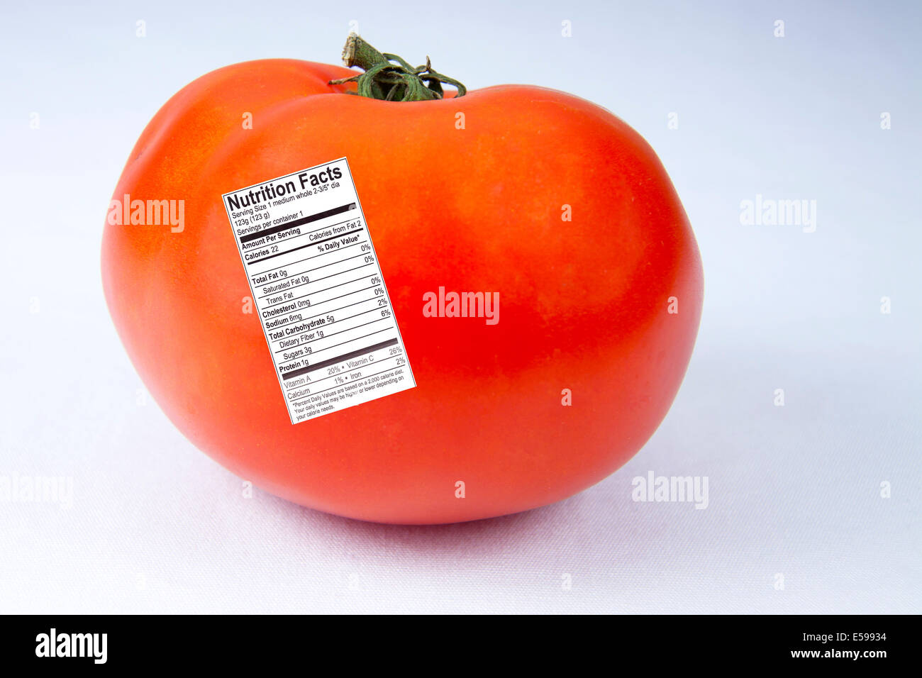 Red, ripe tomato with nutrition fact label attached Stock Photo
