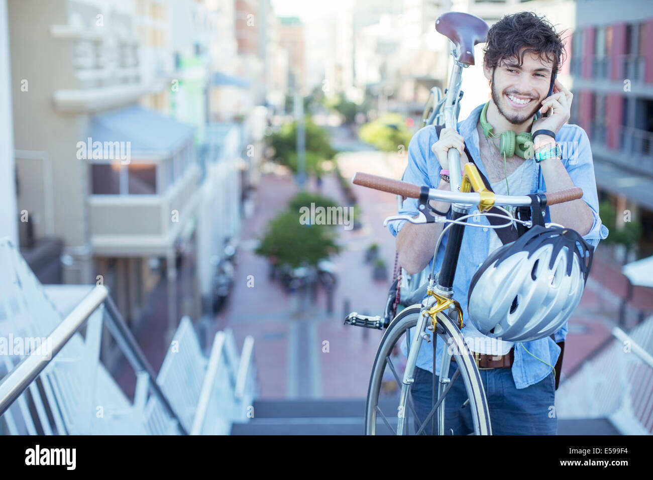 Man carrying bicycle on city steps Stock Photo
