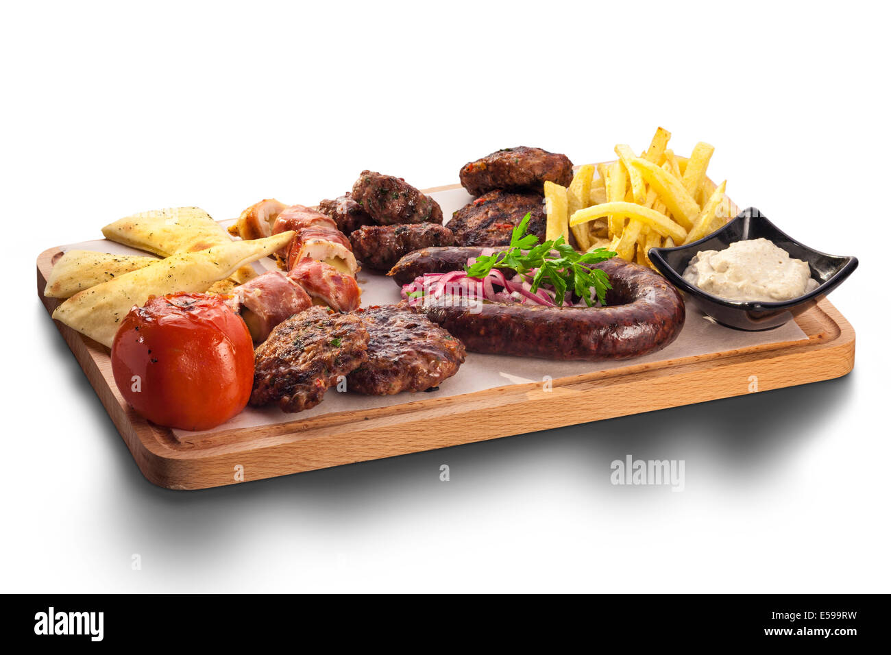 Wholesome platter of mixed meats including grilled steak, nachos, crispy crumbed chicken and beef on a bed of fresh leafy green Stock Photo
