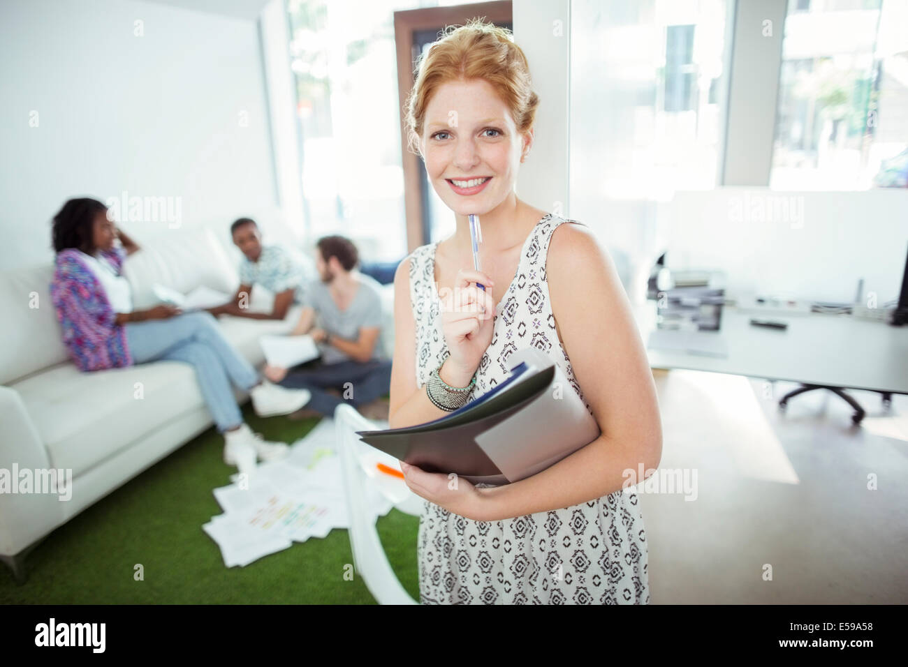 Woman carrying folders on city street Stock Photo