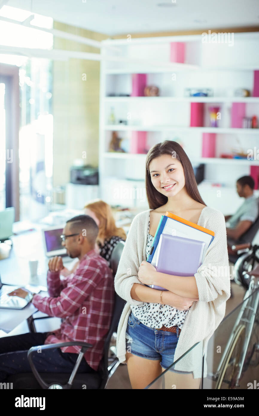 Woman carrying folders in office Stock Photo