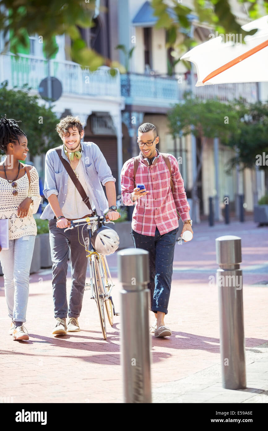 Friends walking together on city street Stock Photo