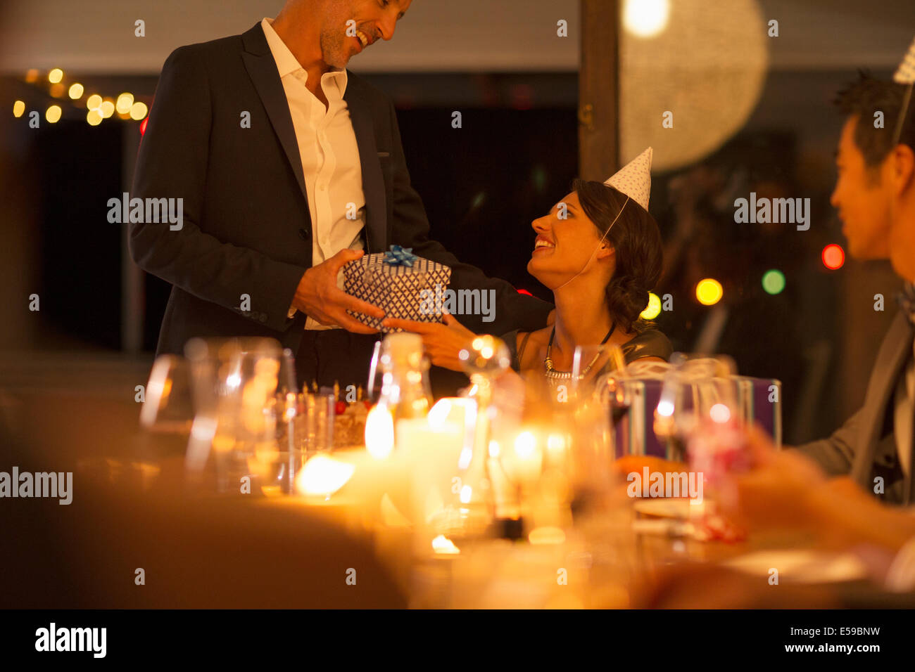 Man giving wife gift at birthday party Stock Photo