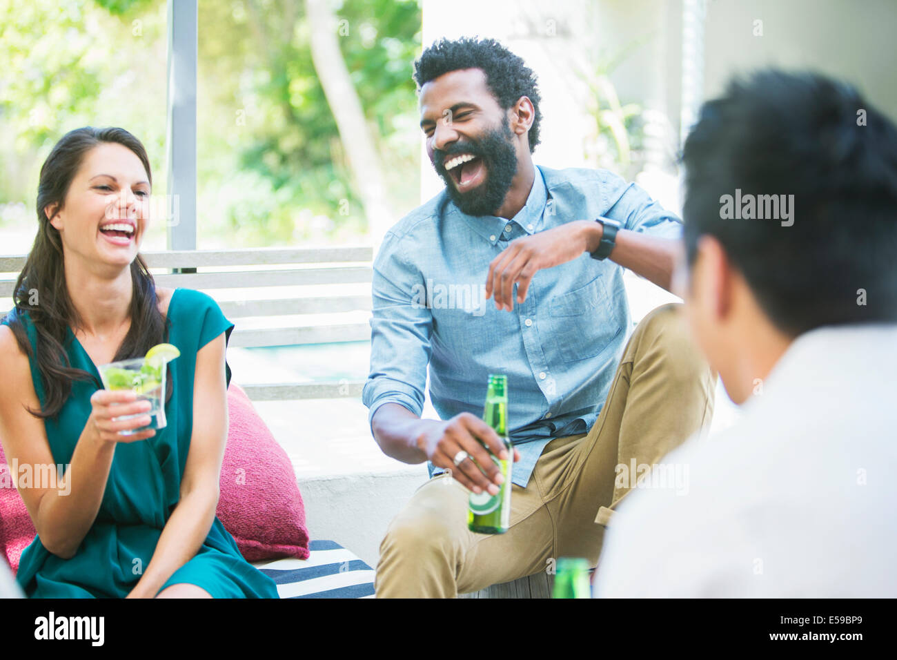 Friends laughing together at party Stock Photo