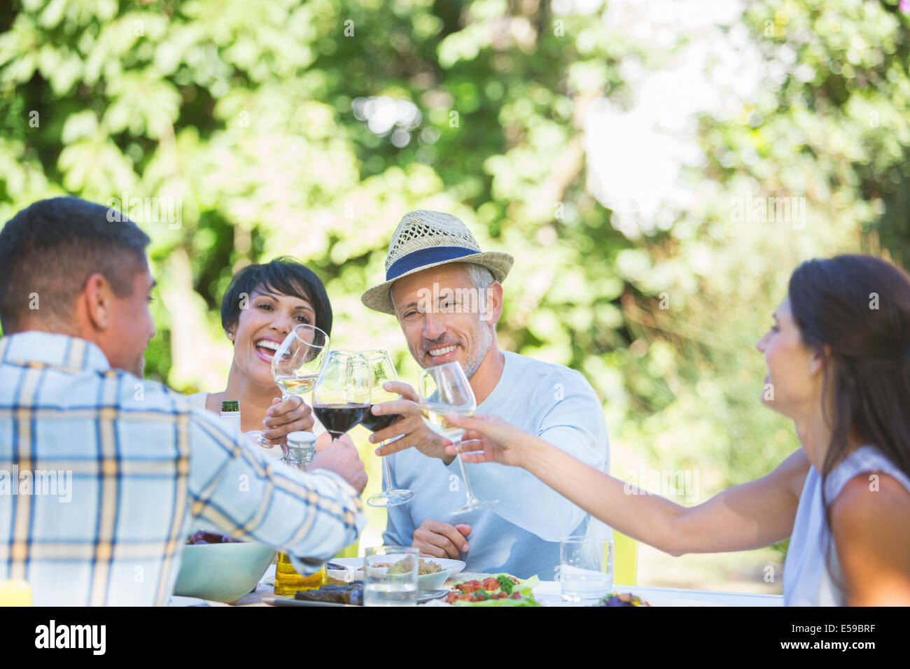 Friends toasting each other at table outdoors Stock Photo