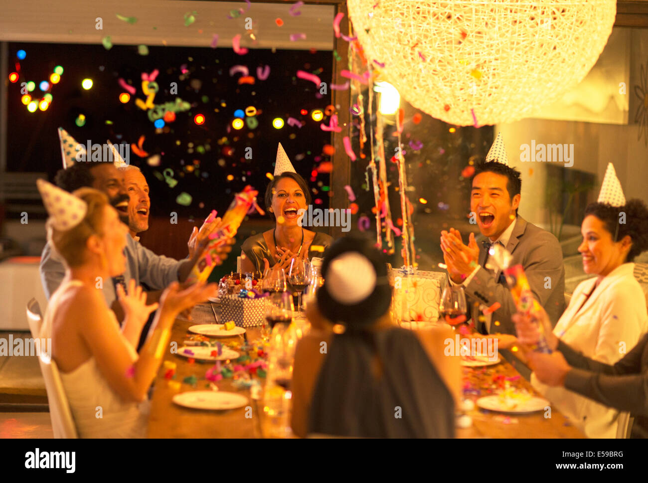 Friends throwing confetti at birthday party Stock Photo