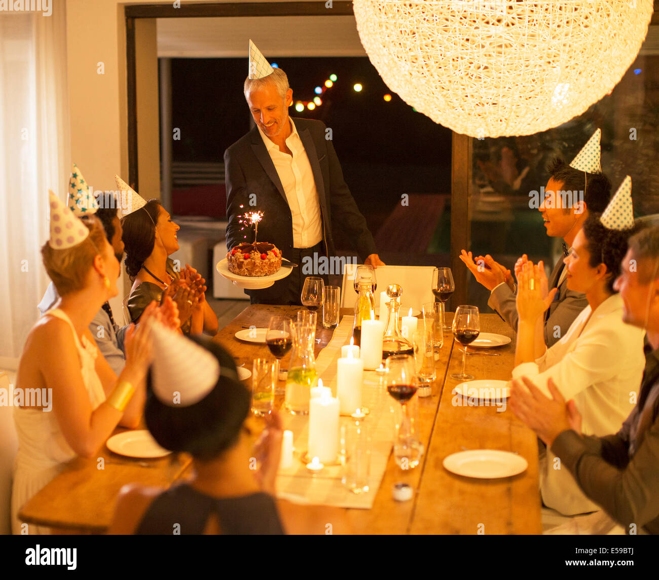 Man serving birthday cake at party Stock Photo