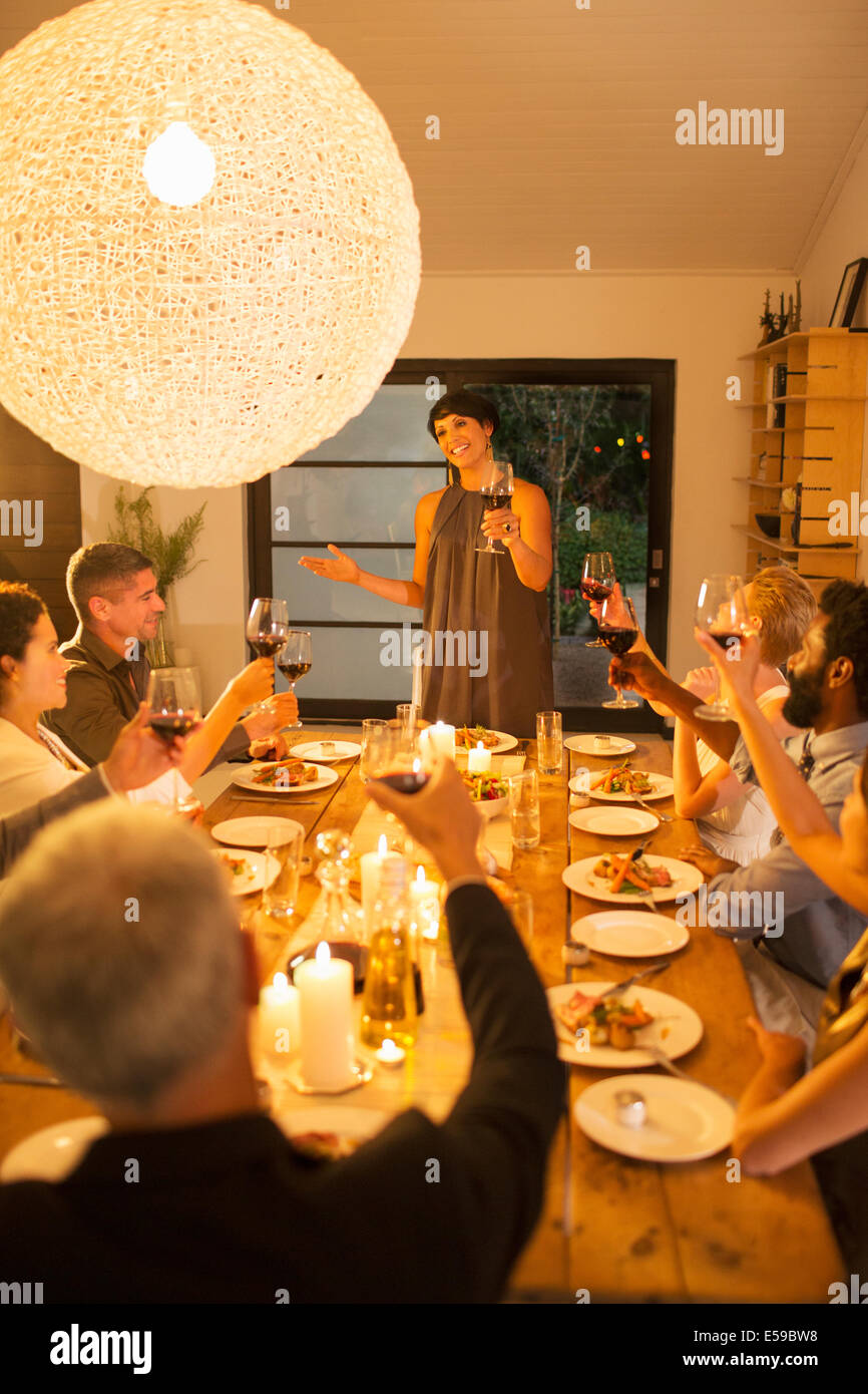 Woman giving toast at dinner party Stock Photo Alamy