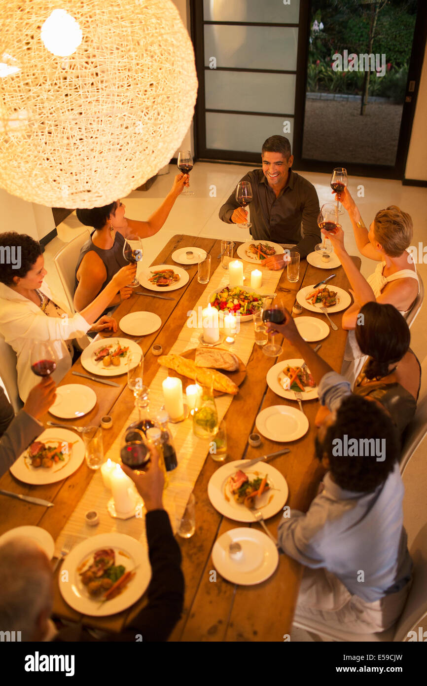 Friends toasting each other at dinner party Stock Photo