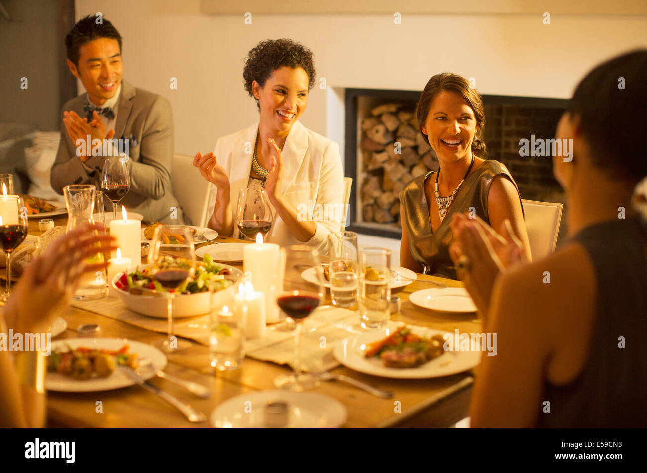 Friends applauding at dinner party Stock Photo