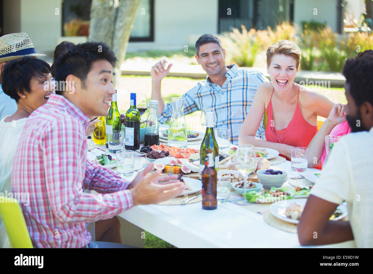 Friends talking at table outdoors Stock Photo