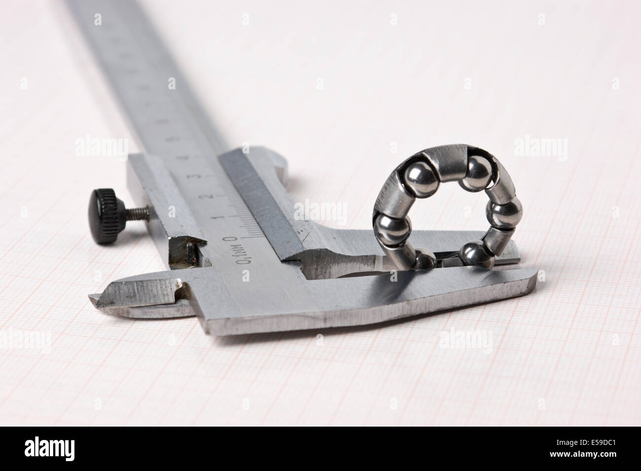 caliper and bearing against the background of graph paper Stock Photo Alamy
