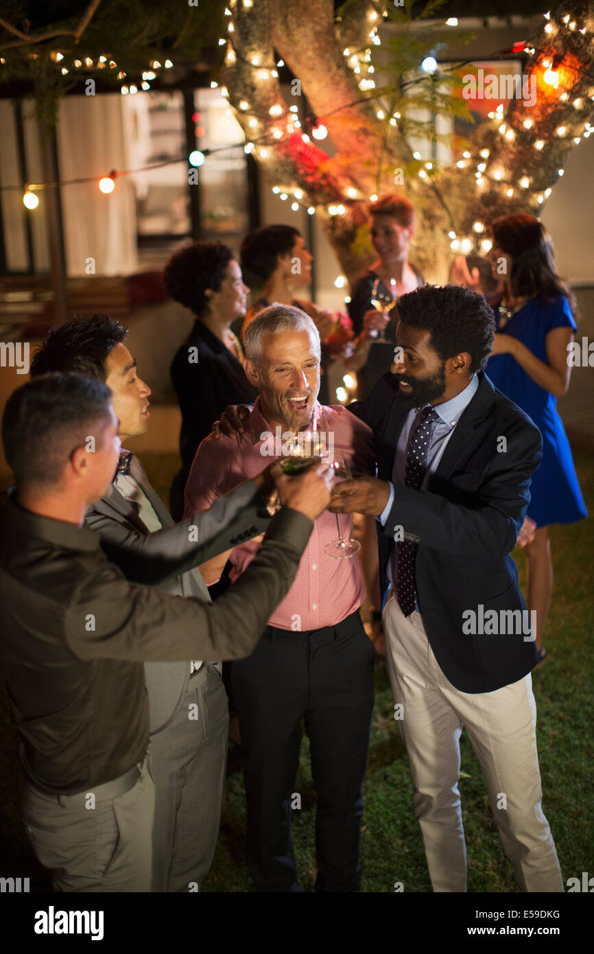 Men toasting each other at party Stock Photo
