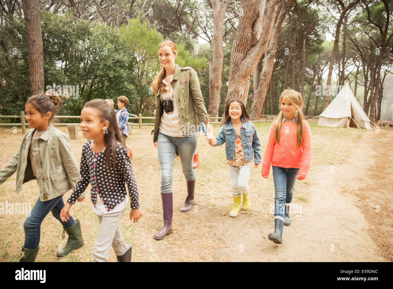 Students and teacher walking on dirt path Stock Photo