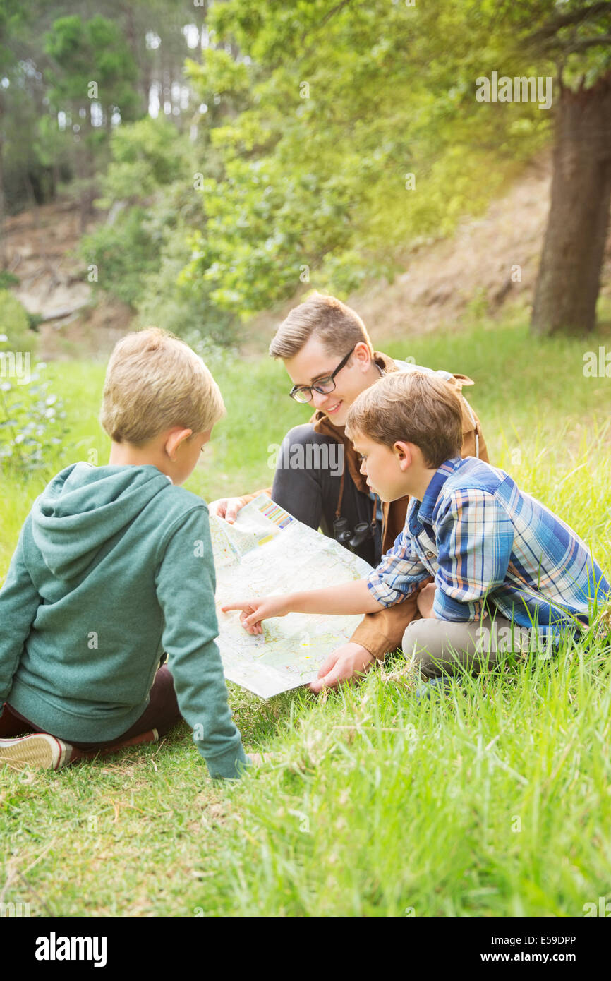 Students and teacher reading map in field Stock Photo