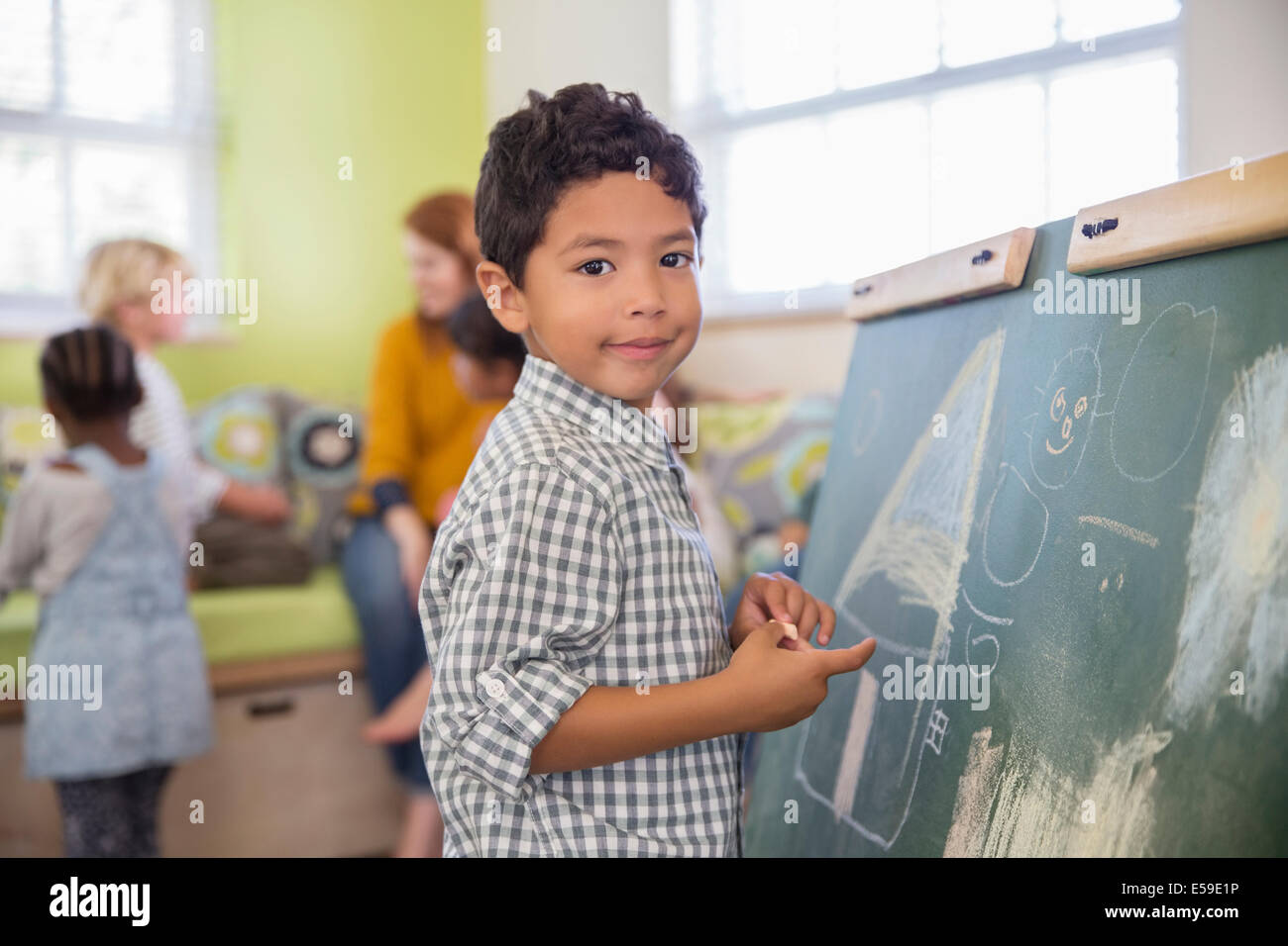 Student drawing on chalkboard in classroom Stock Photo