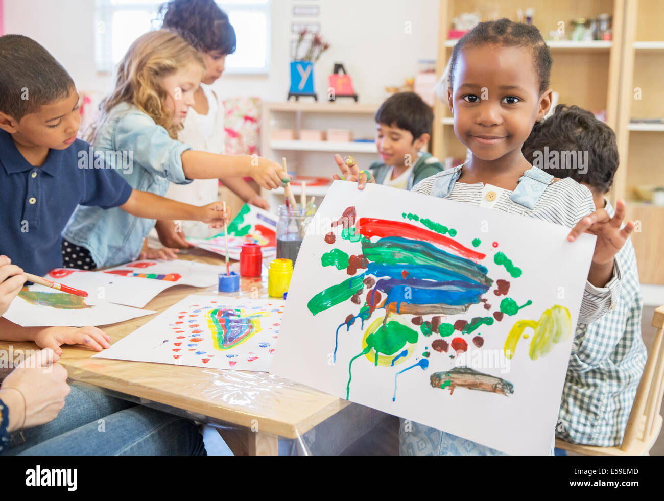 Student showing off finger painting in classroom Stock Photo