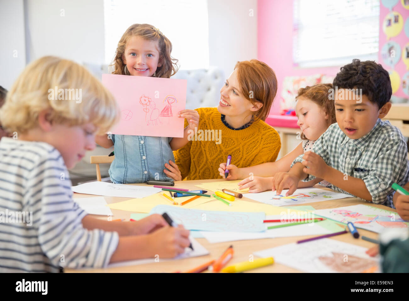 Student showing off drawing in classroom Stock Photo