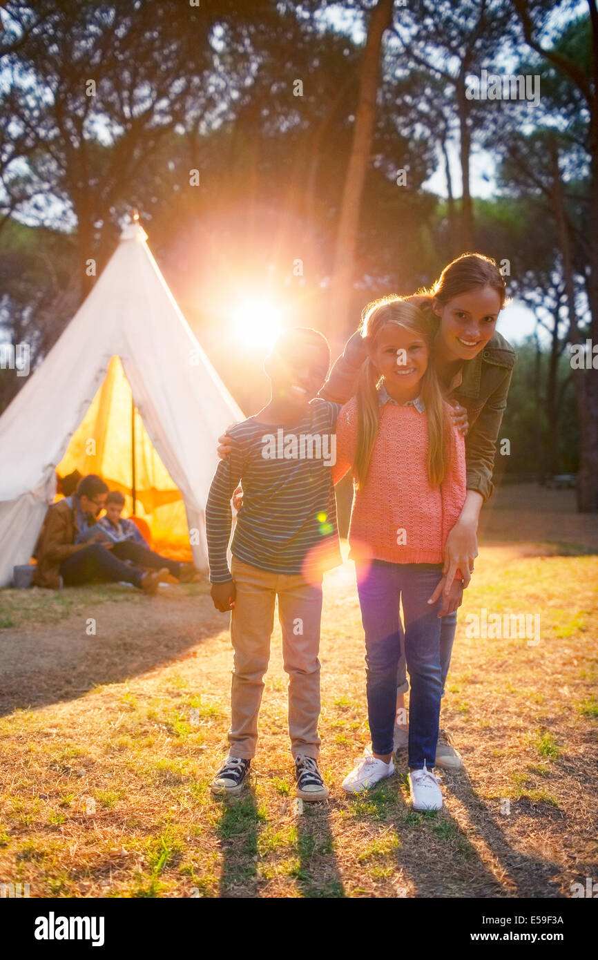 Students and teacher smiling by teepee at campsite Stock Photo