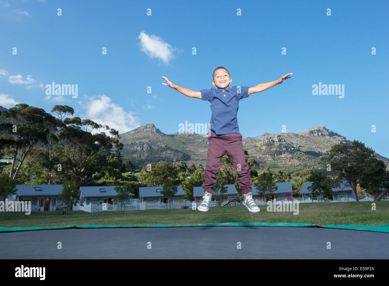 Boy jumping on trampoline outdoors Stock Photo