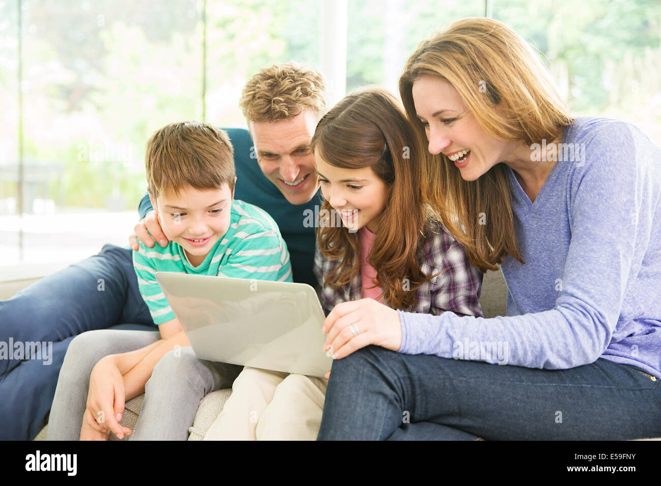 Family using laptop in living room Stock Photo
