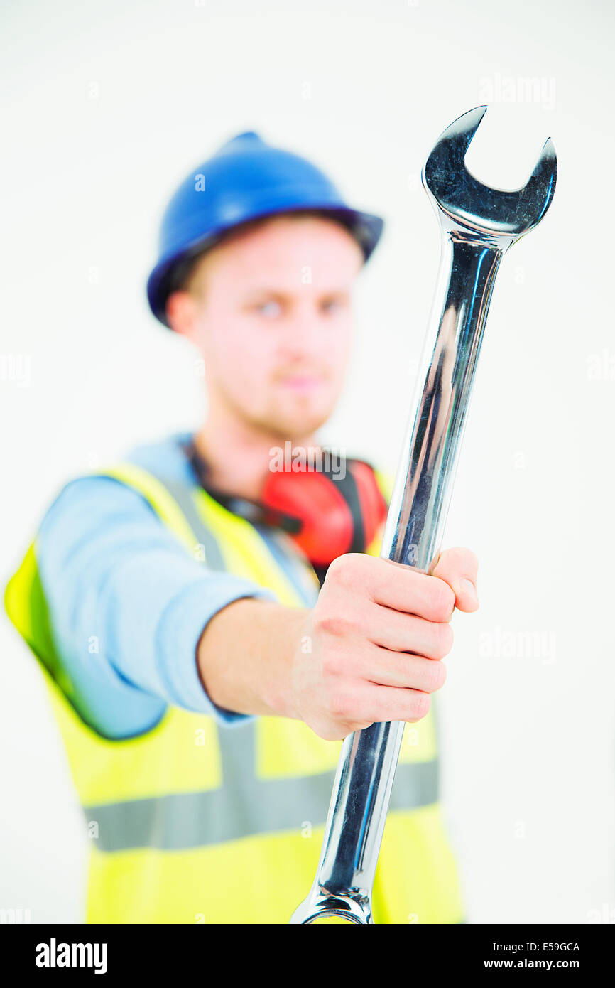 Construction worker holding large wrench Stock Photo