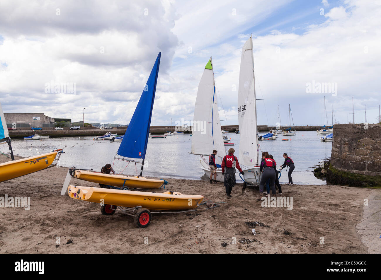 Sailing school students launching a sailboat for a lesson from Bray, County Wicklow, Ireland. Stock Photo