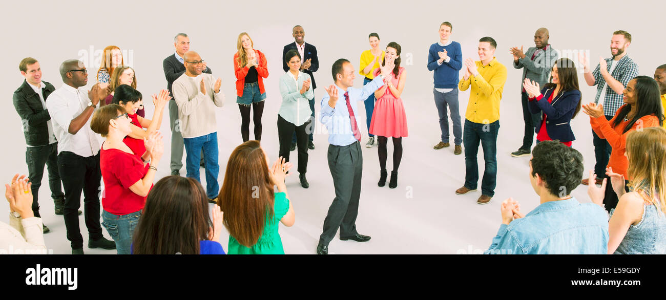 Crowd cheering for businessman Stock Photo