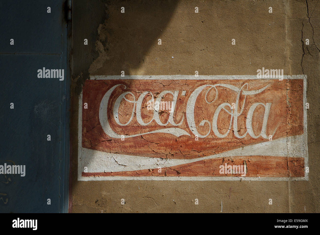 Old weathered Coca Cola logo painted on a wall. Place an abandoned bottling plant in Tychy, Poland. Stock Photo
