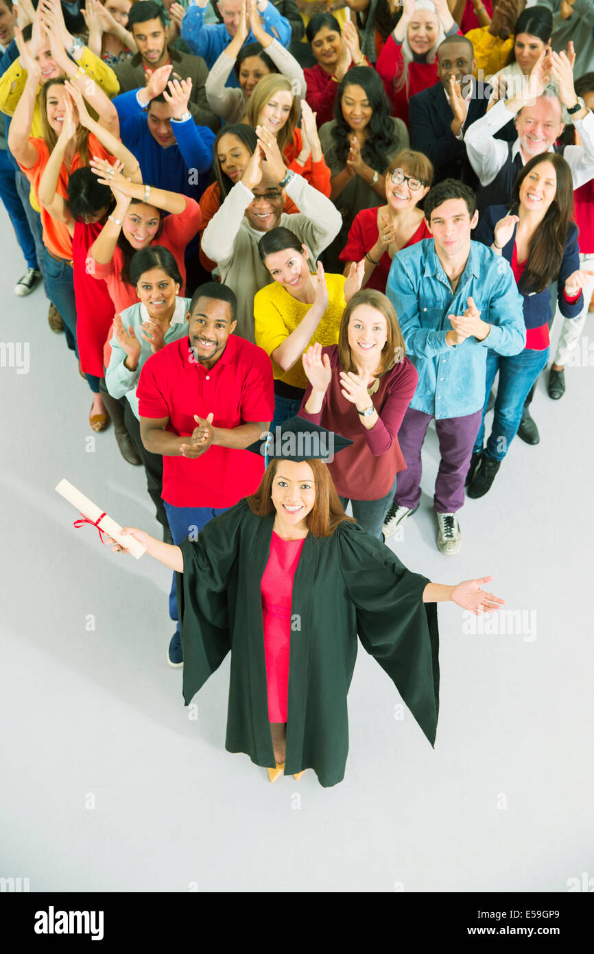 Clapping crowd behind graduate Stock Photo