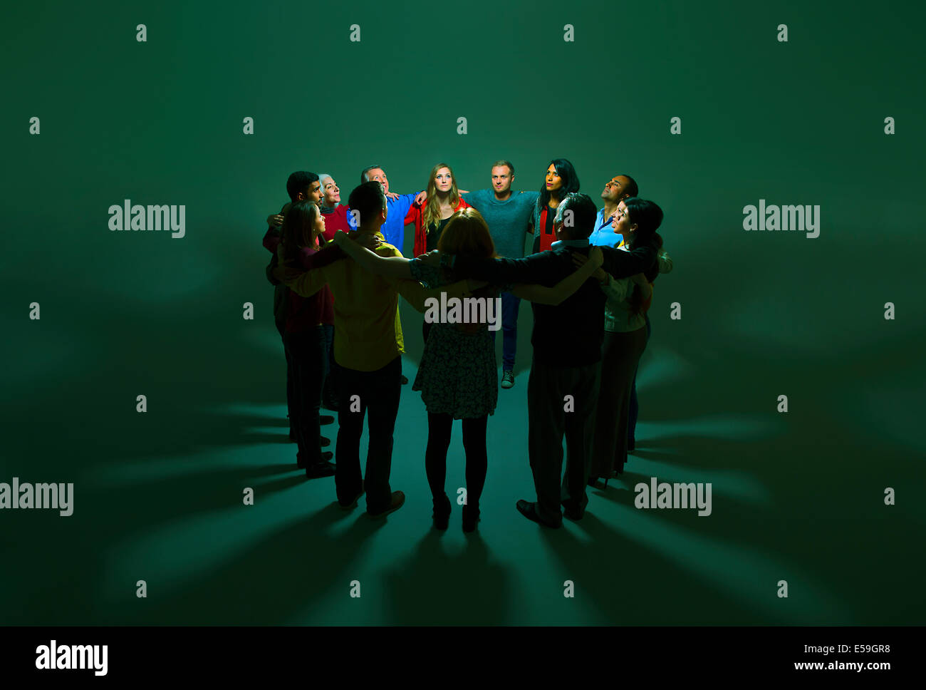 Business people in circle around bright light Stock Photo