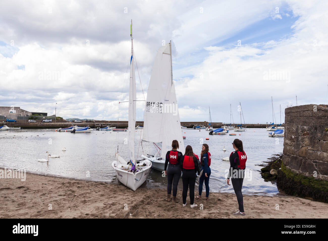 Sailing school students launching a sailboat for a lesson from Bray, County Wicklow, Ireland. Stock Photo