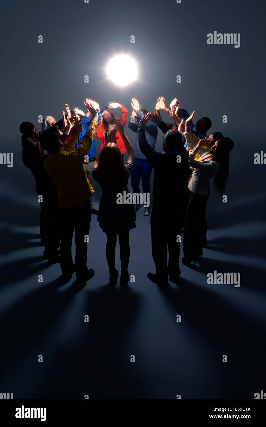 Business people shielding eyes from bright light Stock Photo