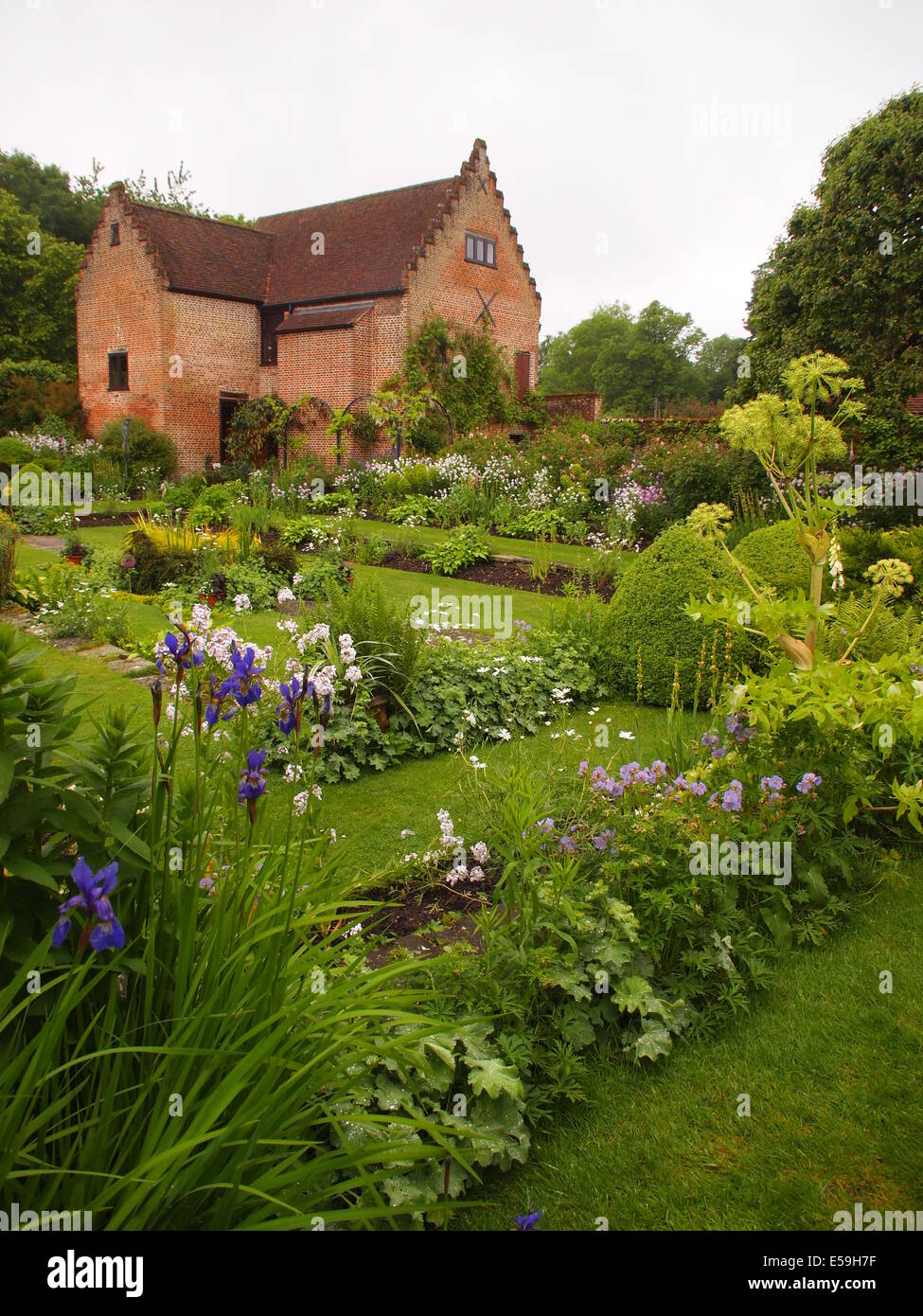 Portrait view of Chenies Manor Sunken garden in May, including the pavilion and apple tree with double flower borders and paths. Stock Photo