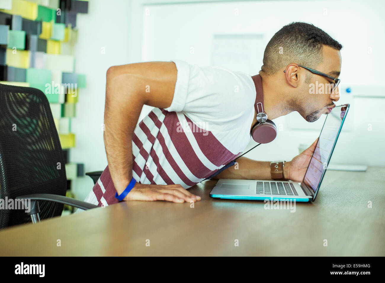 Man kissing laptop in office Stock Photo
