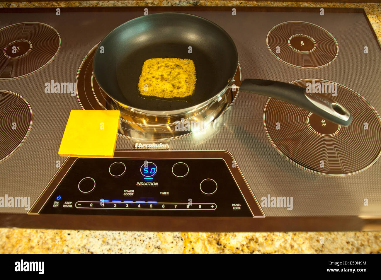Magnetic energy of Thermador Induction cooktop with melting cheeseMR  Series of 4 images. © Myrleen Pearson Stock Photo