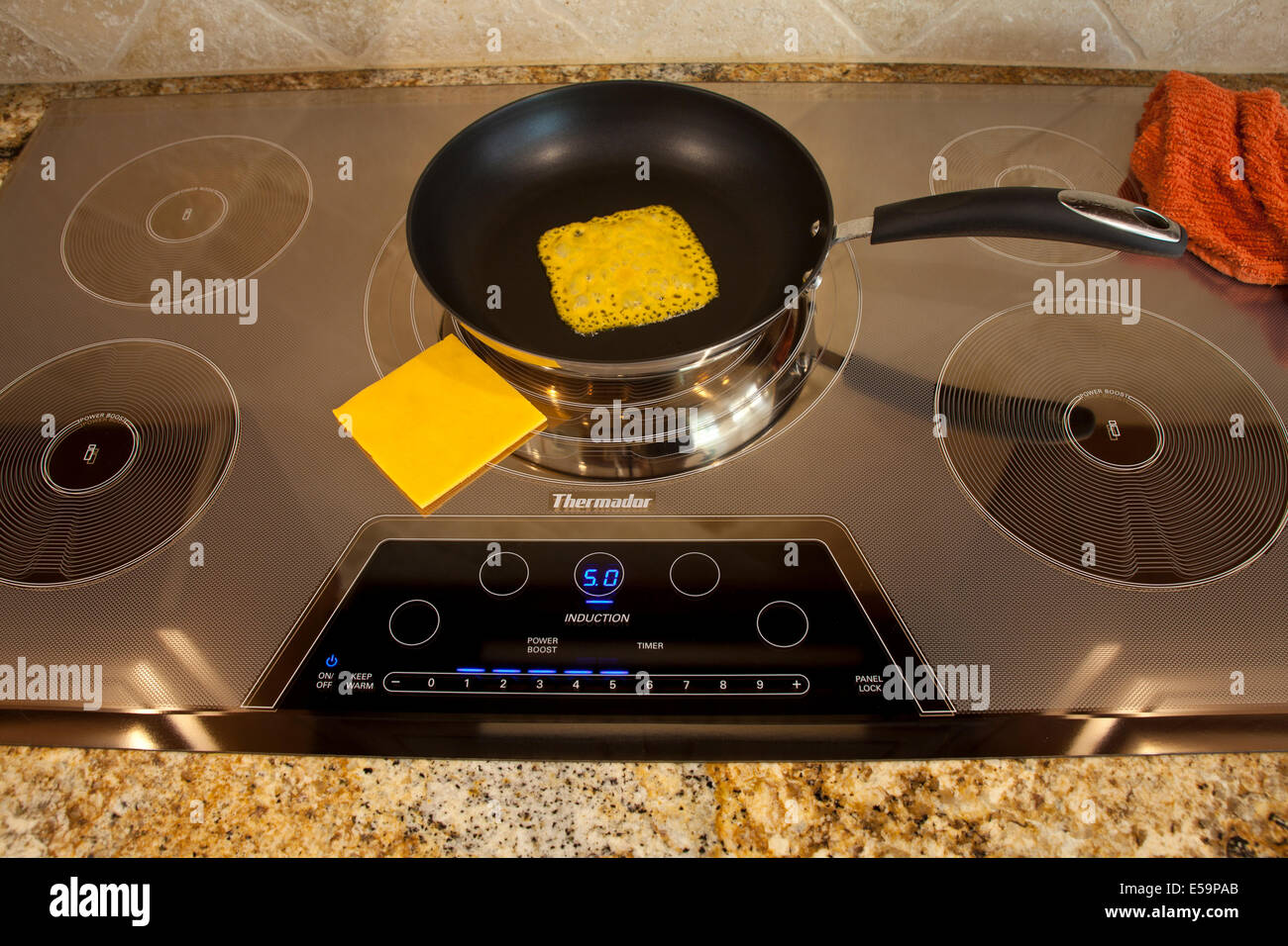 magnetic energy of Thermador Induction cooktop with melting cheese  Series of 4 images. MR  © Myrleen Pearson Stock Photo