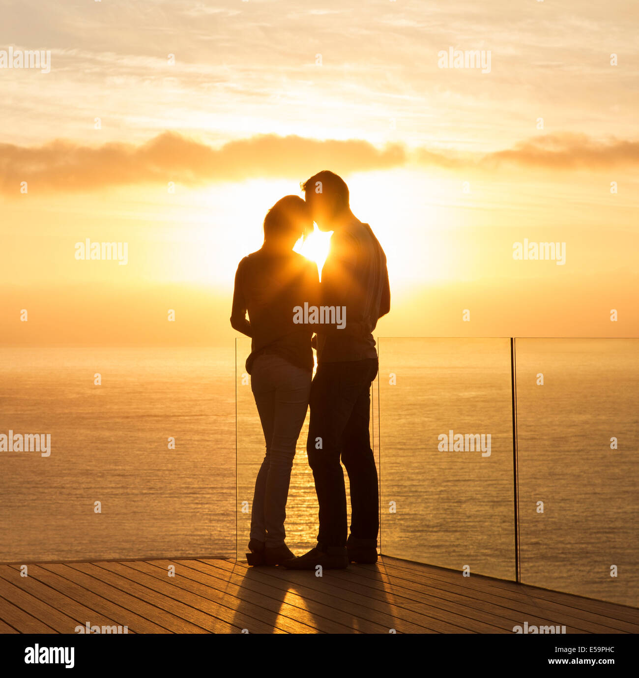 Silhouette of couple at sunset over ocean Stock Photo