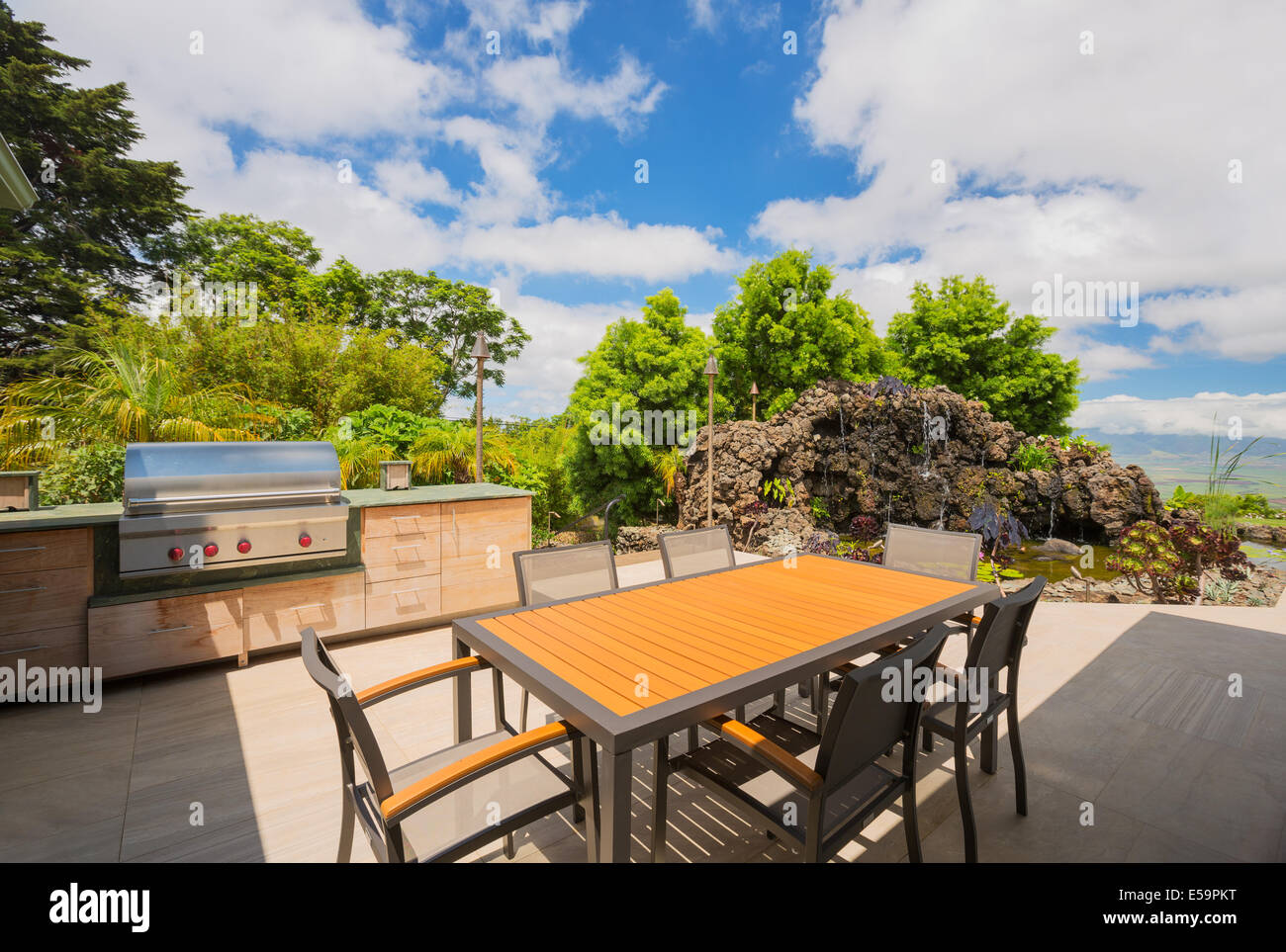 Backyard patio with BBQ grill and dining table on deck Stock Photo