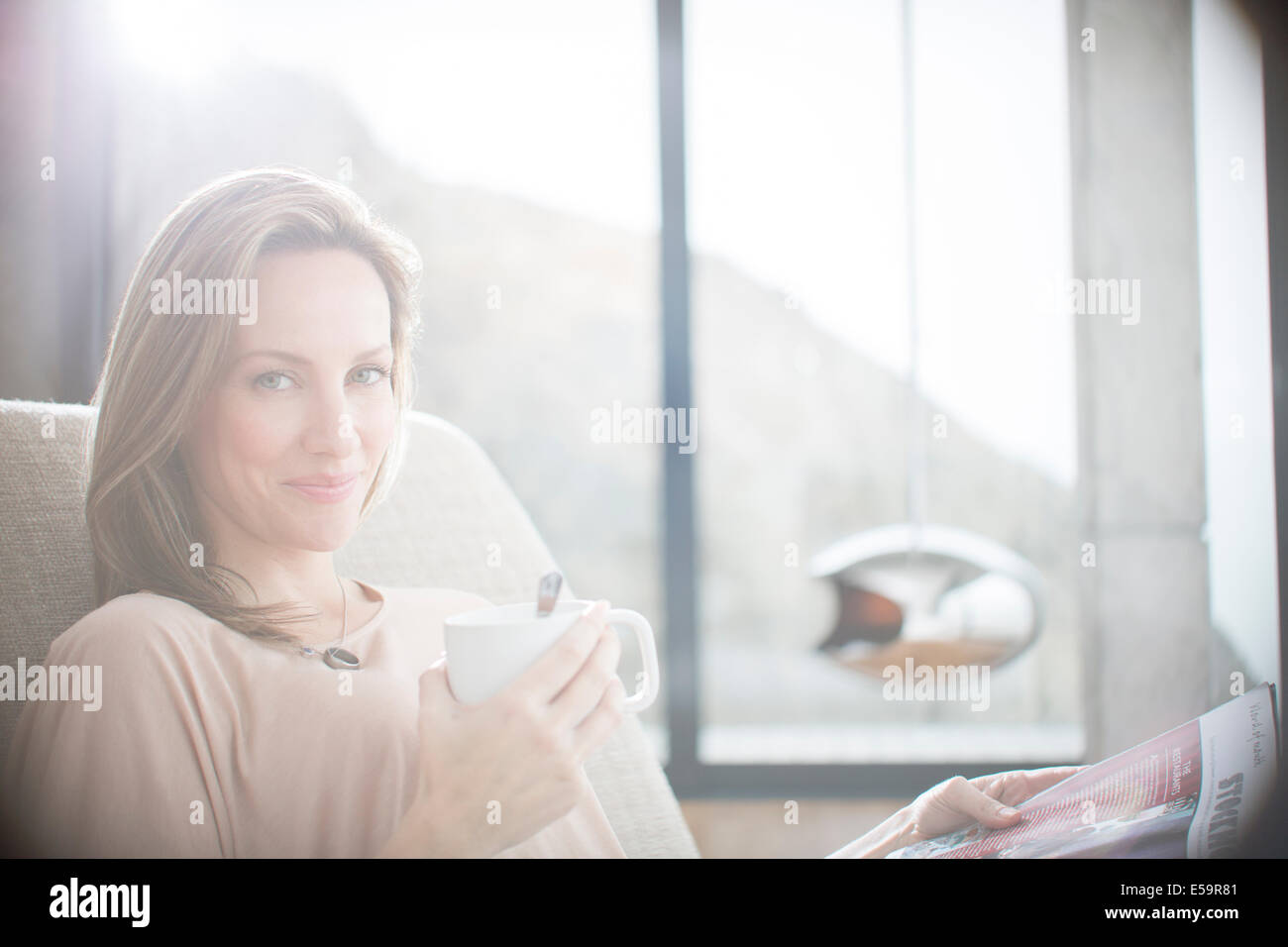 Woman having cup of coffee on sofa Stock Photo