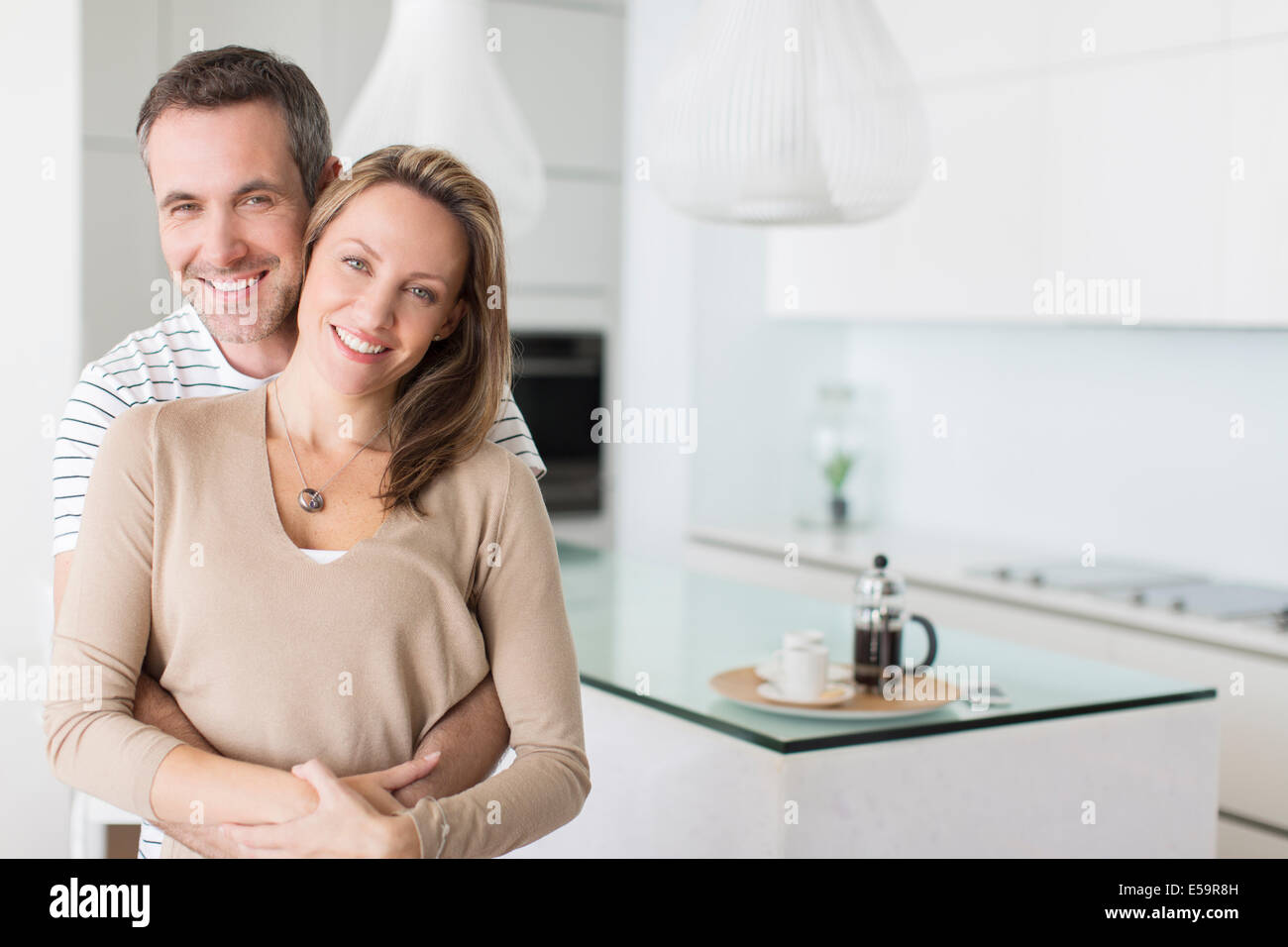 Couple hugging in modern kitchen Stock Photo