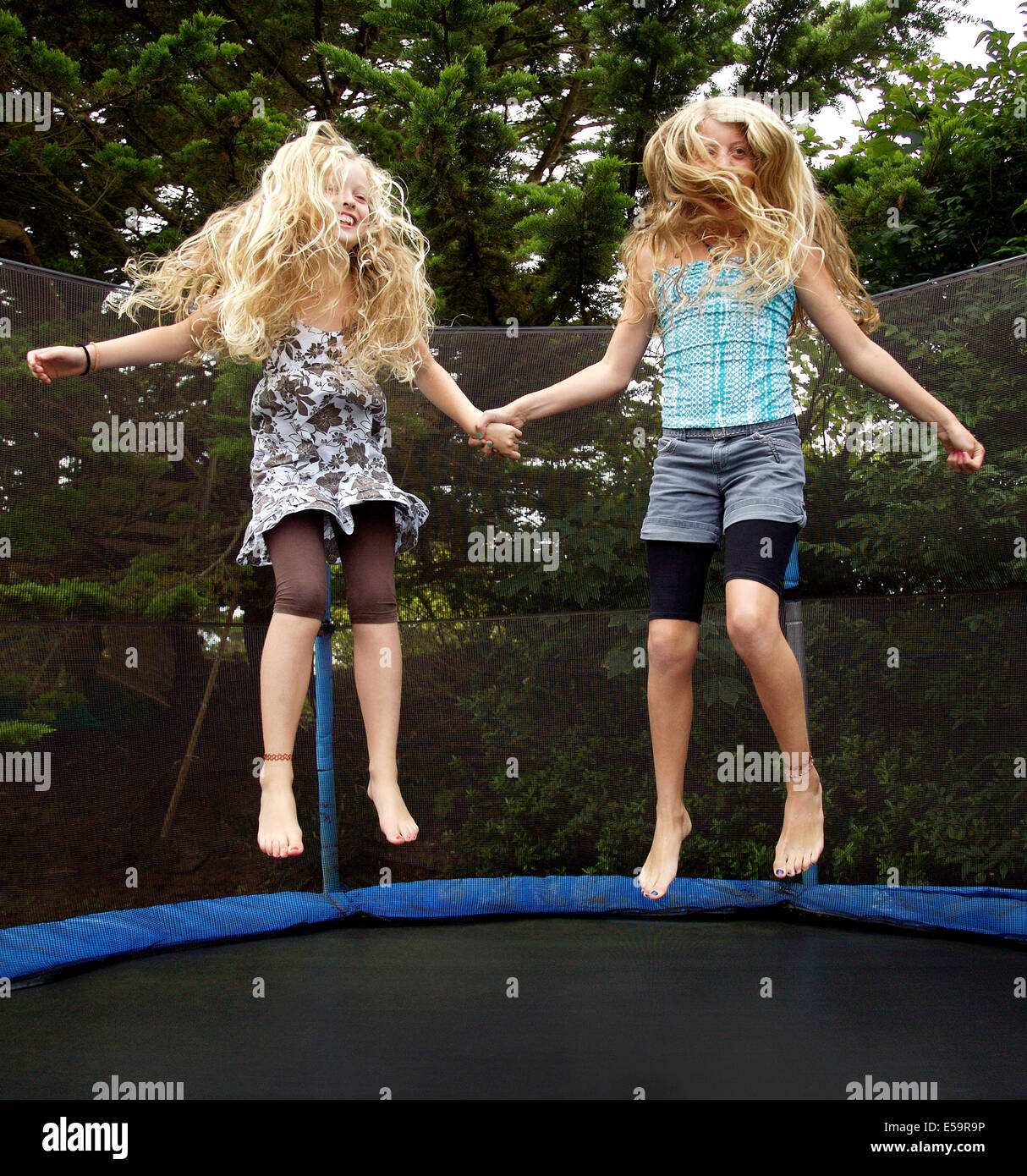 Girls jumping on trampoline outdoors Stock Photo
