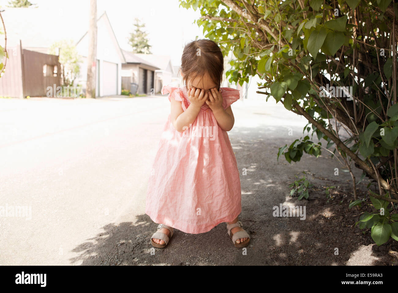 Girl covering her face outdoors Stock Photo - Alamy