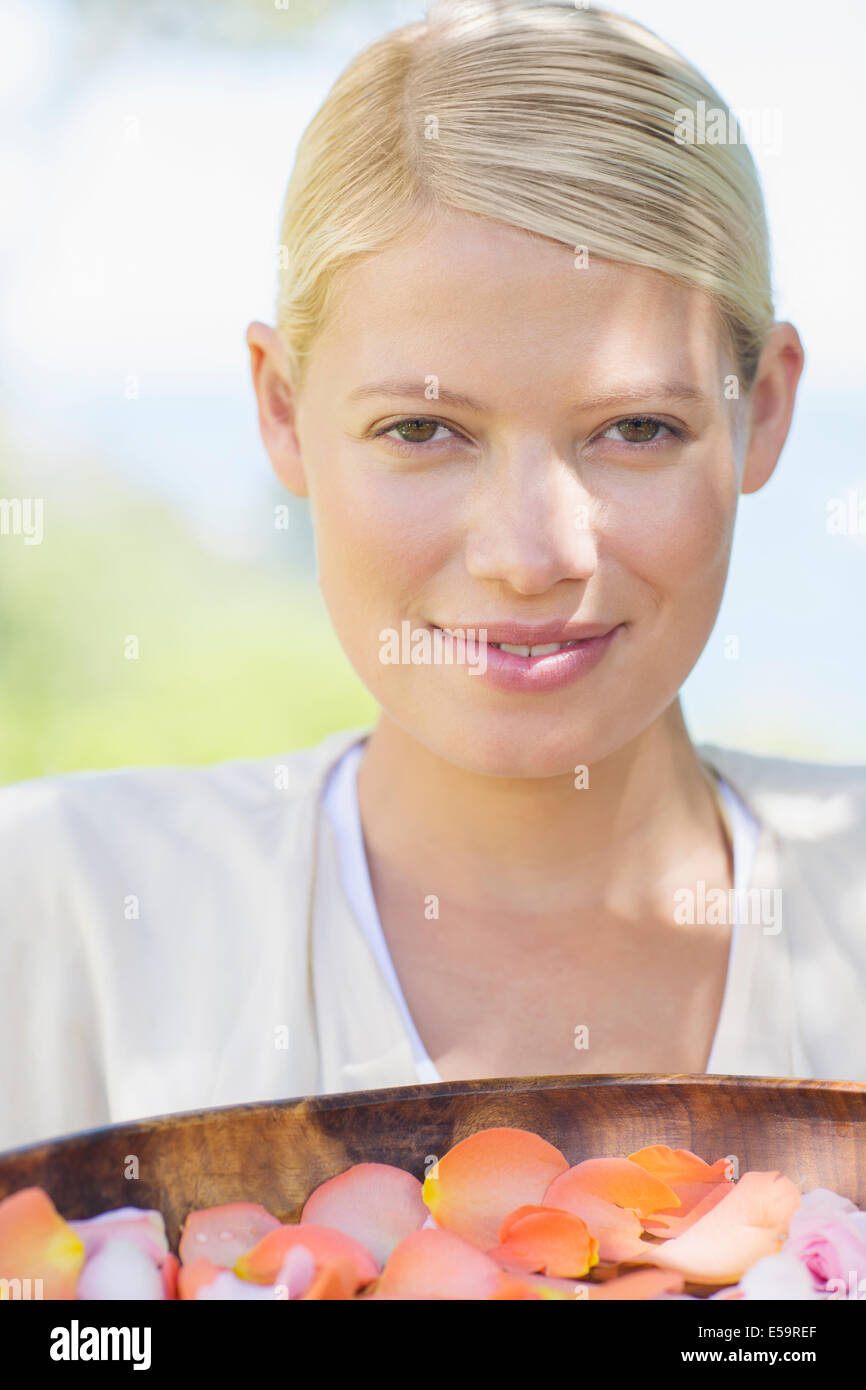 Woman carrying bowl of flower petals Stock Photo