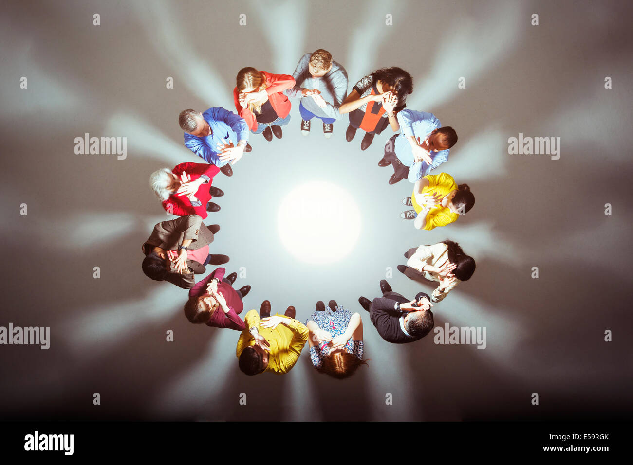Crowd forming circle around bright light Stock Photo